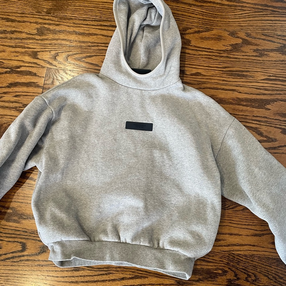 Gray pullover hoodie with a prominent hood and ribbed cuffs